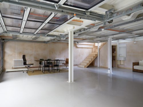 Ground floor garage with staircase to studio and sectional doors